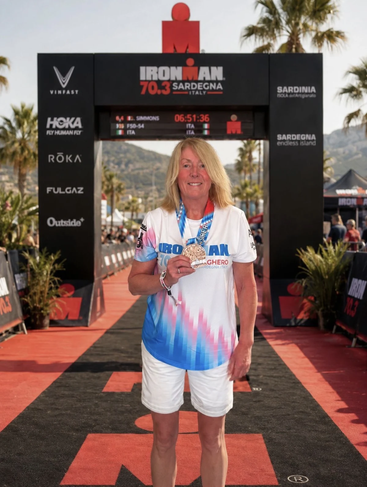 Donna with her finisher medal on the IRONMAN 70.3 Sardegna red carpet