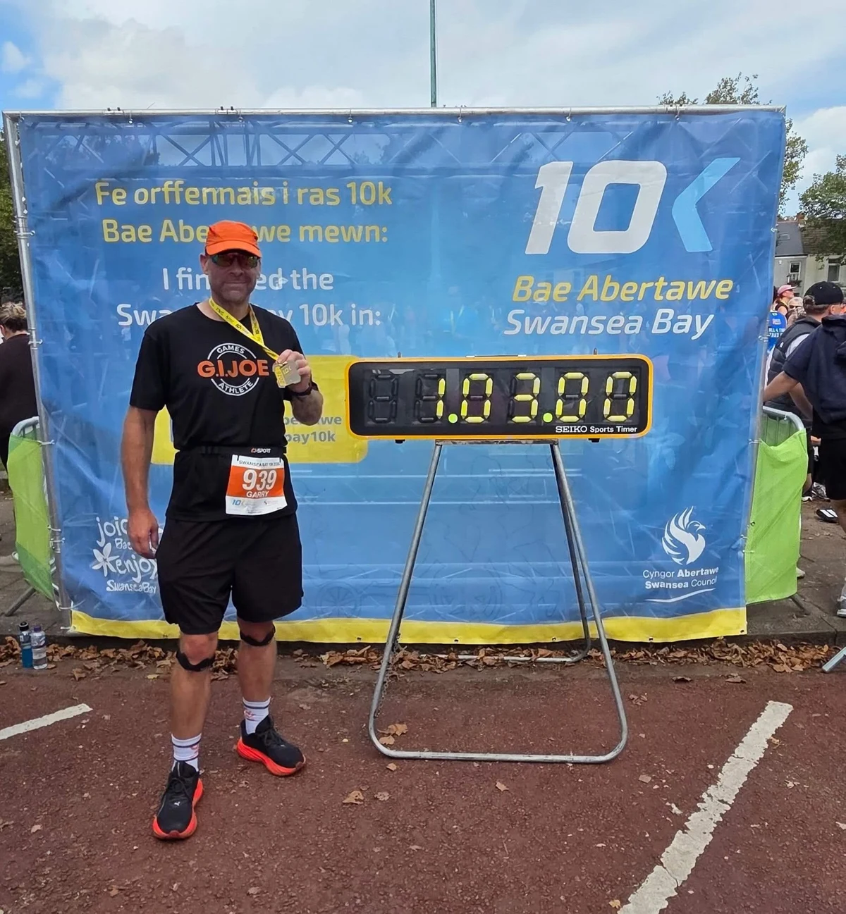 Garry holding his medal after his first Swansea Bay 10K